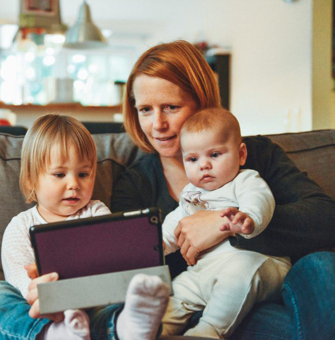 Adoptive parent and children read iPad